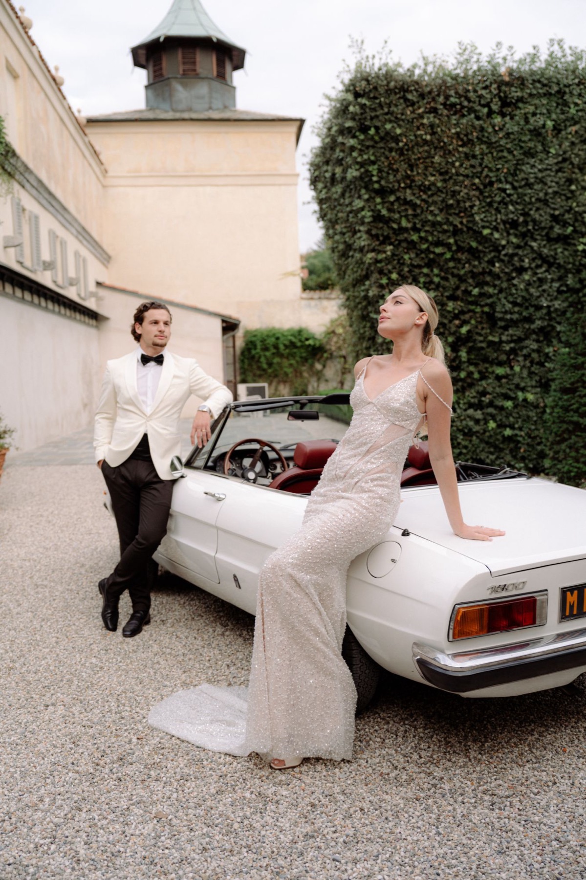 Couple leaning on a vintage convertible at an Italian villa