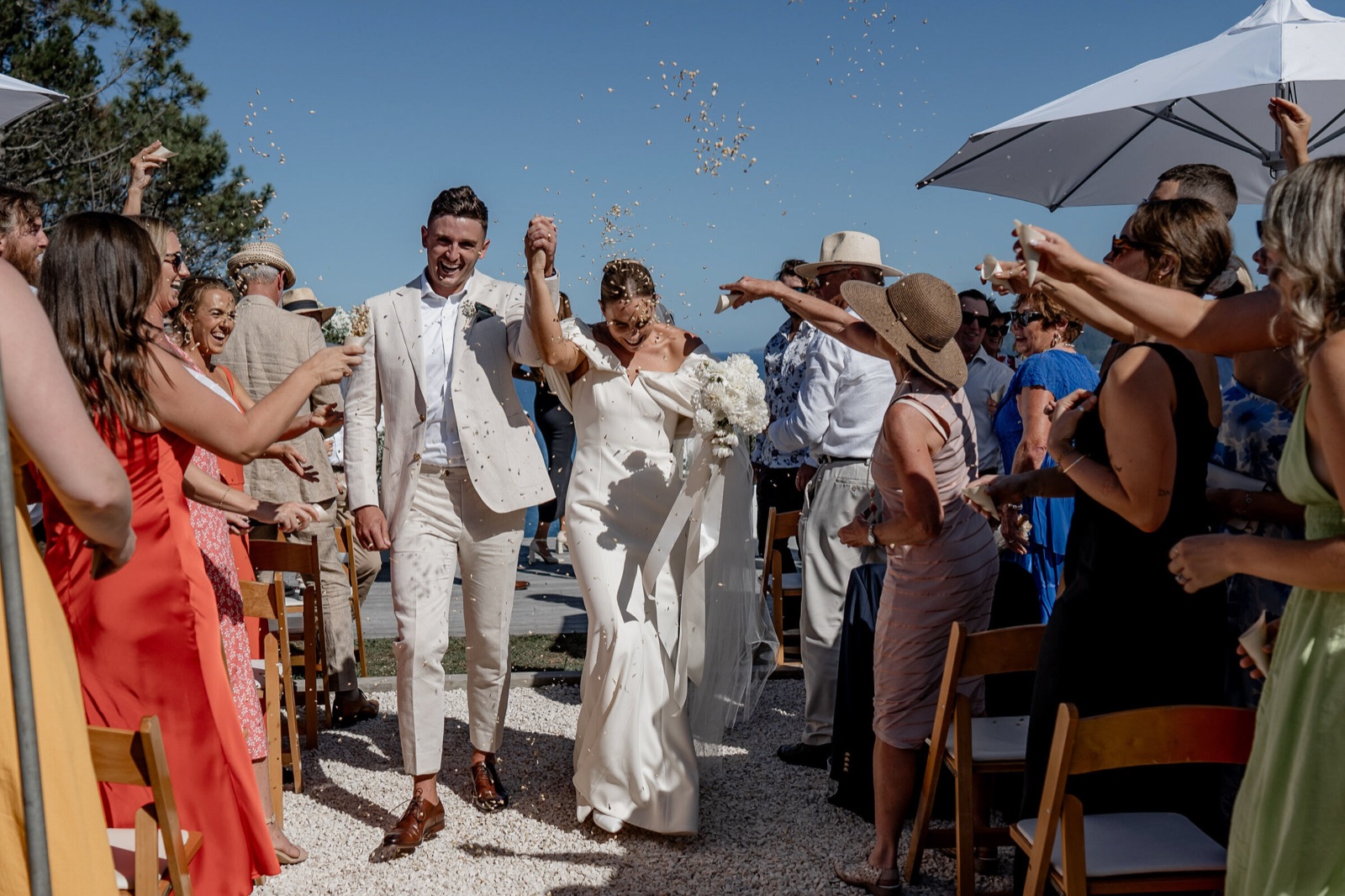 Couple walking back down the aisle through confetti