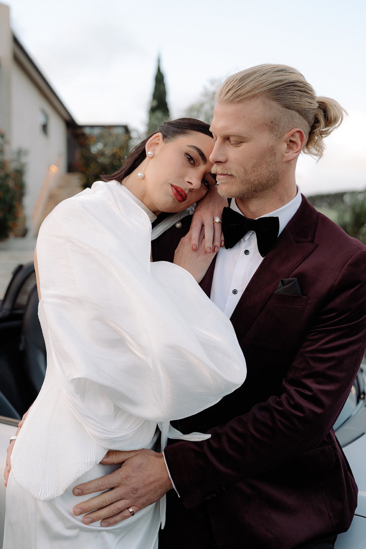 Editorial portrait of a bride resting on her groom's shoulder