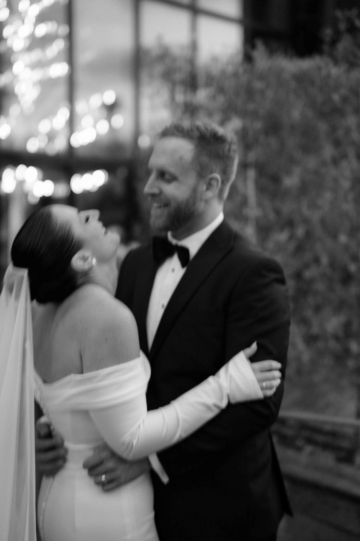 Bride in long gloves embracing her groom at night