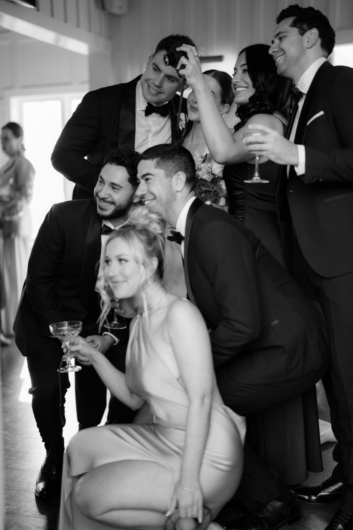 Wedding party crowding together for a film camera photo