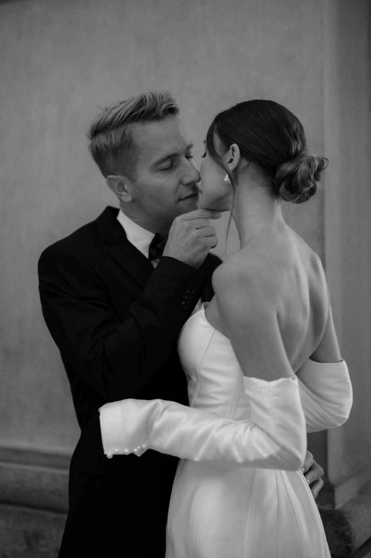 Groom lifting his bride's chin for a kiss in Milan